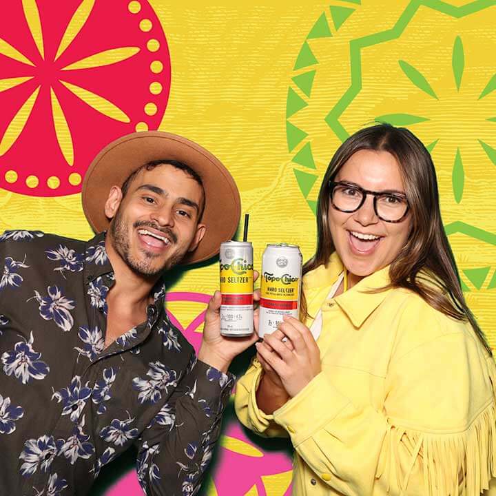 Snapshot-Photo-Booth-Product-Launch A man and a woman posing with Topo Chico drinks at a patio launch